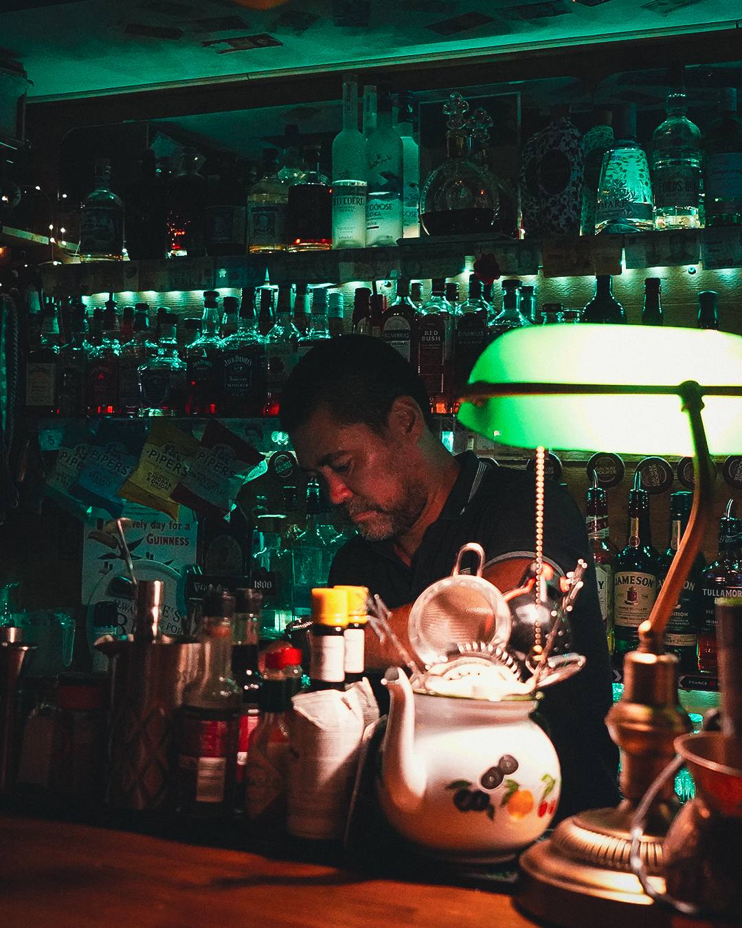 Barman préparant un cocktail sous une lampe verte